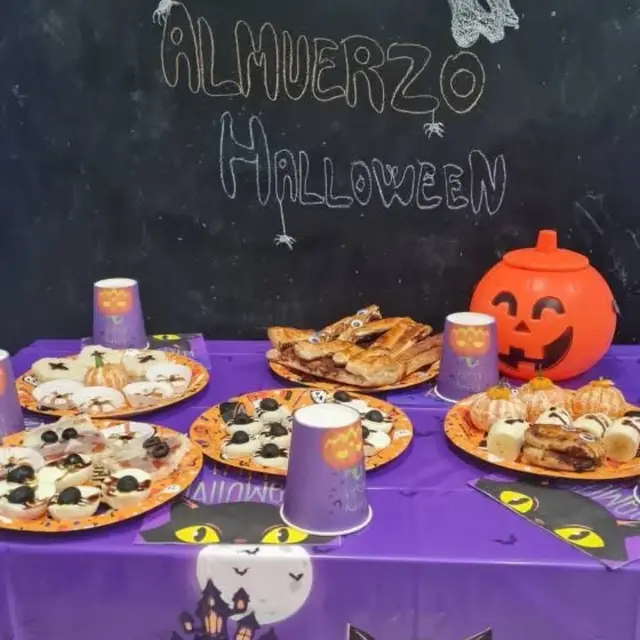 Mesa del almuerzo de Halloween con platos decorados y una calabaza